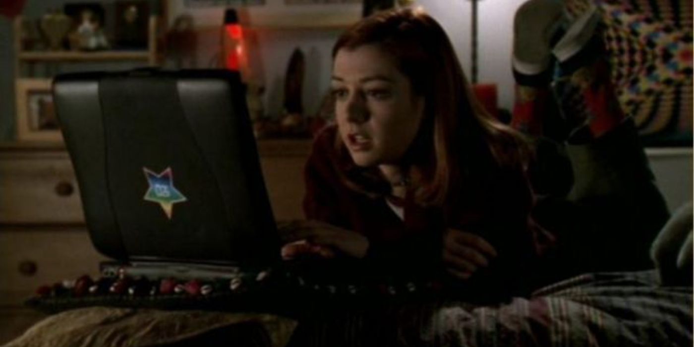 Willow laying on her bed in front of a laptop in Buffy the Vampire Slayer. 
