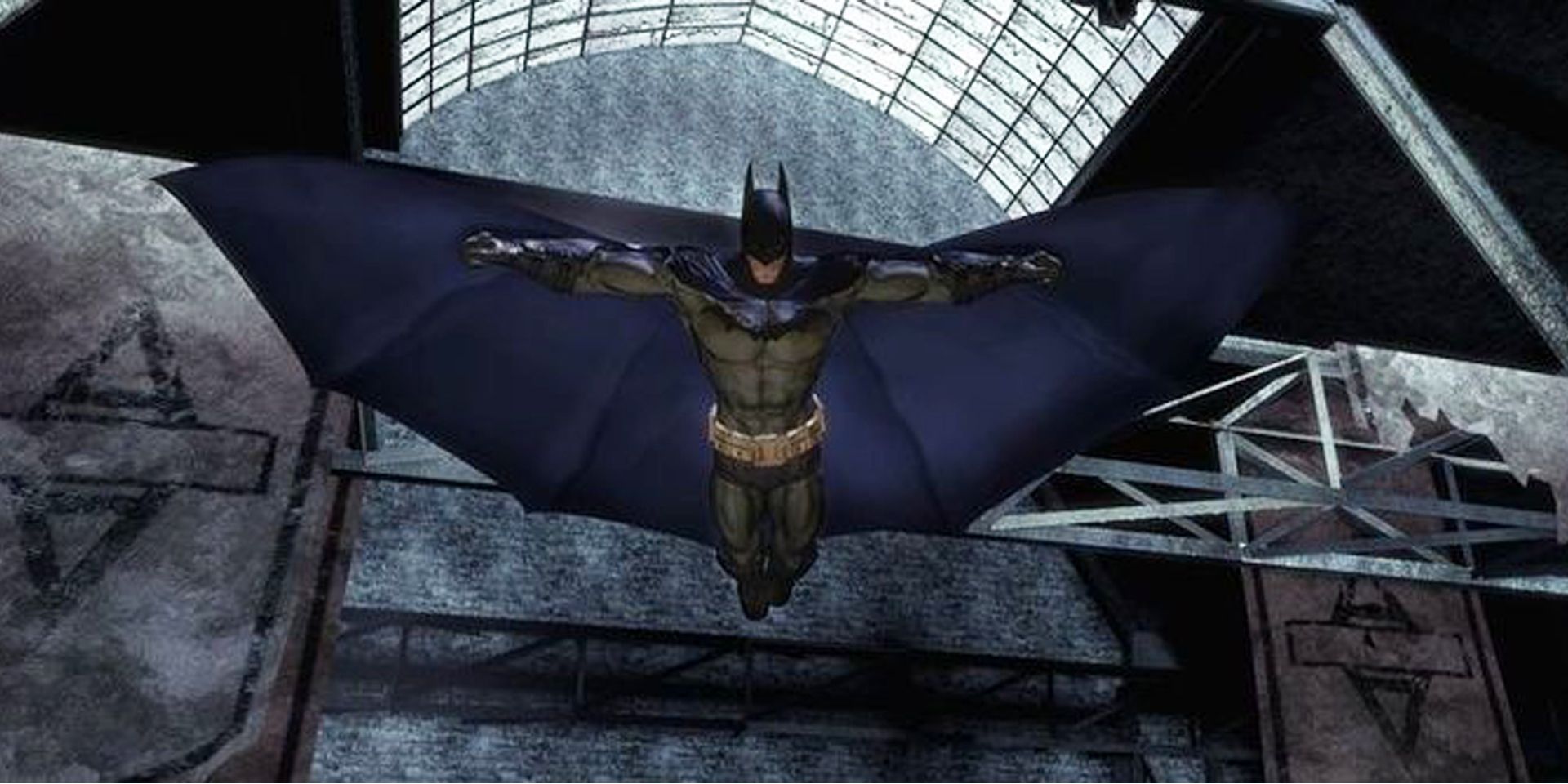 Batman glides across a room in the asylum in Batman Arkham Asylum.
