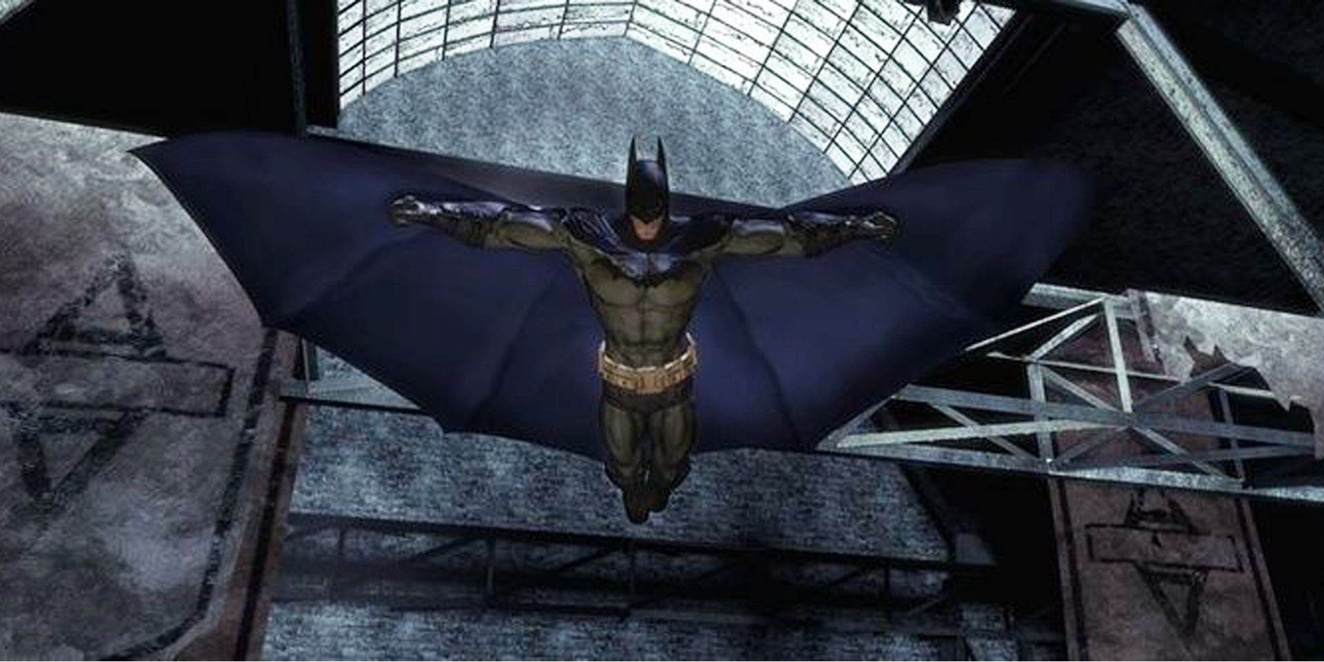 Batman desliza por uma sala no asilo em Batman Arkham Asylum.