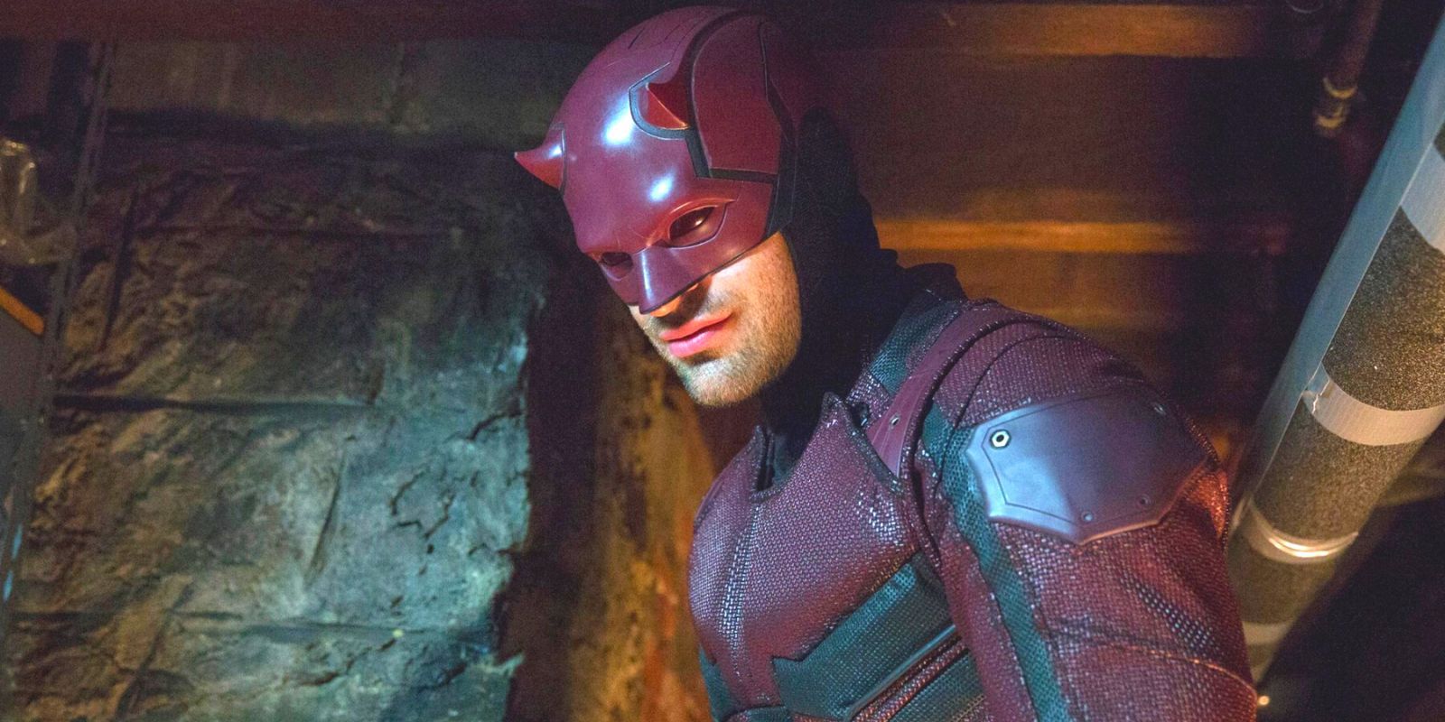 Daredevil in full superhero attire looking down in a basement
