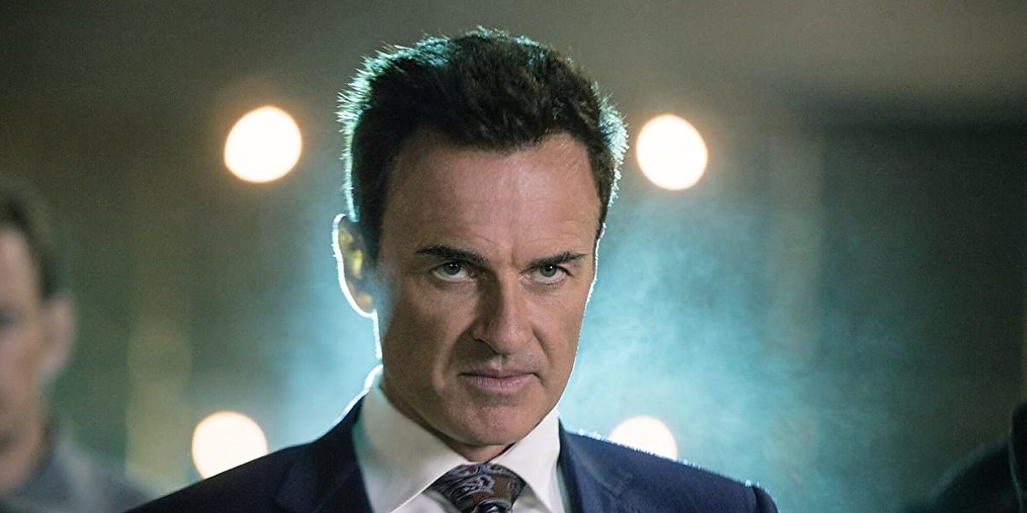 Julian McMahon stares intently in a suit and tie in Runaways