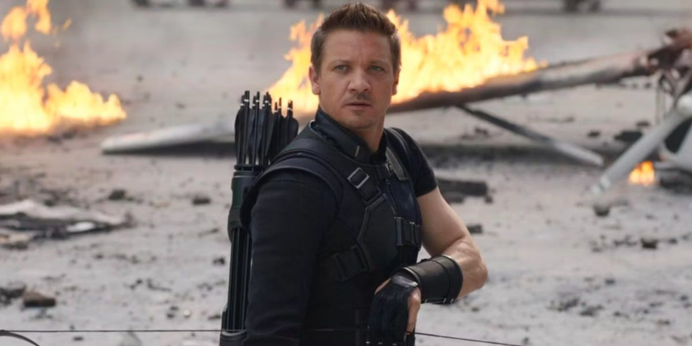 The MCU Hawkeye stands in front of some fiery debris in Captain America: Civil War
