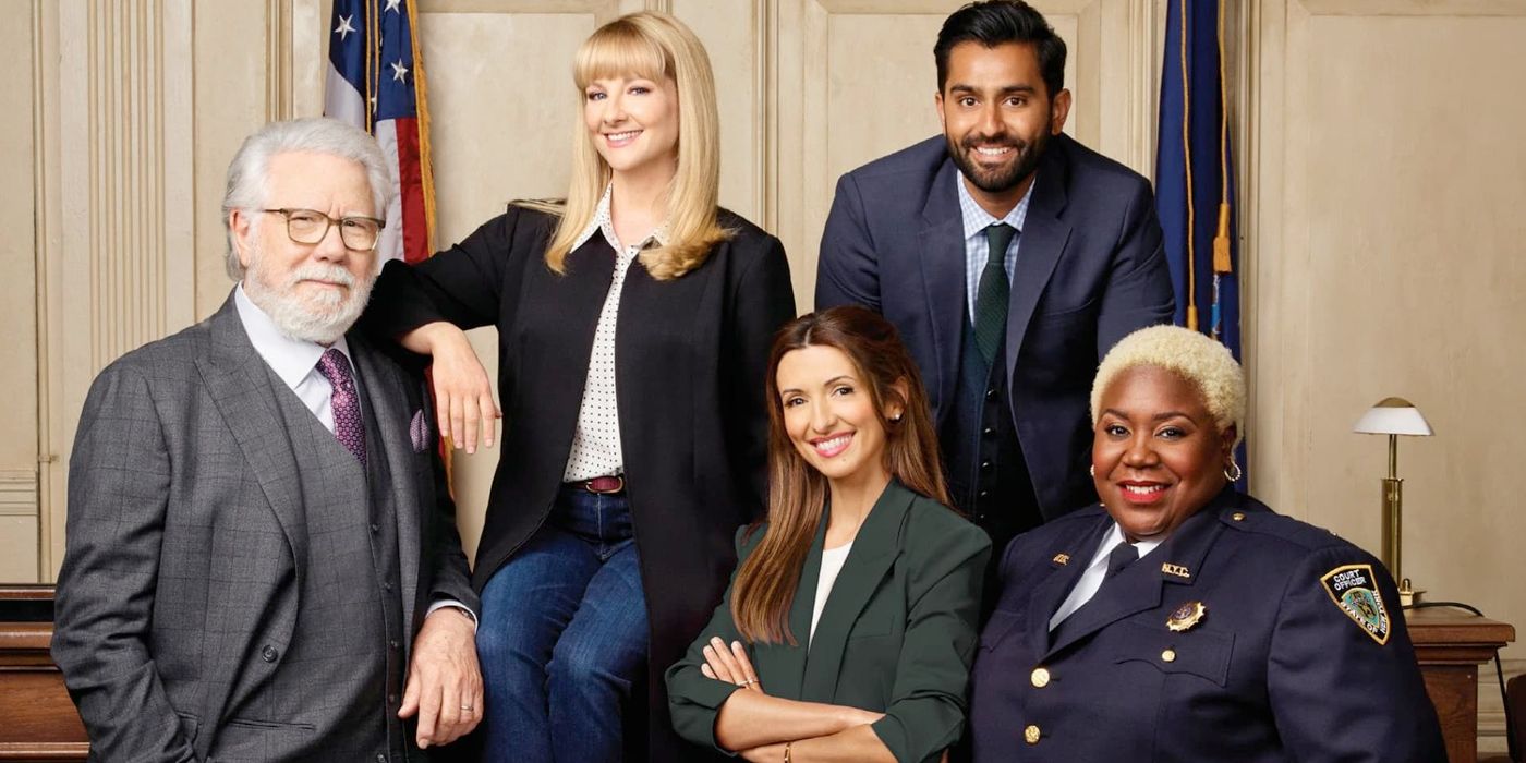 The cast of the Night Court 2023 revival sitting together in a courtroom
