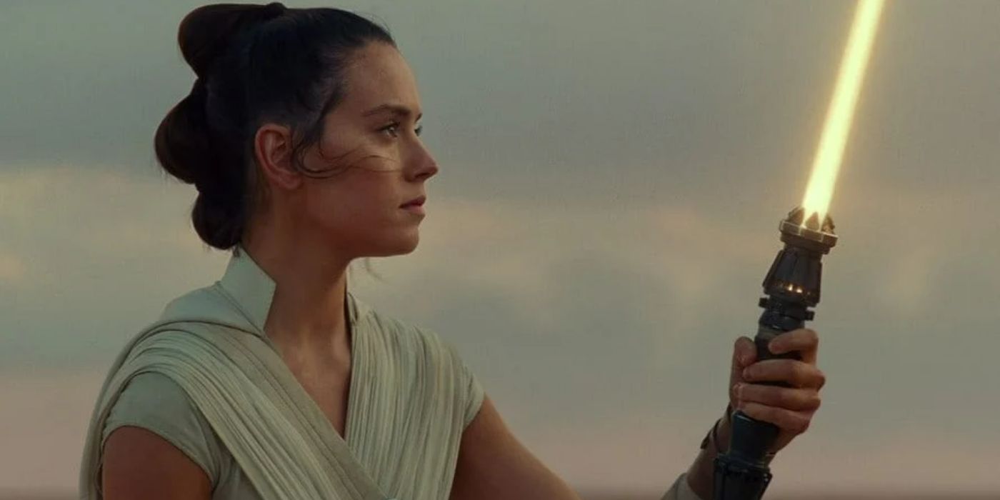 Rey holds up her new lightsaber in The Rise of Skywalker