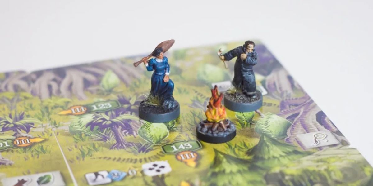 Two characters around a campfire in The 7th Continent board game