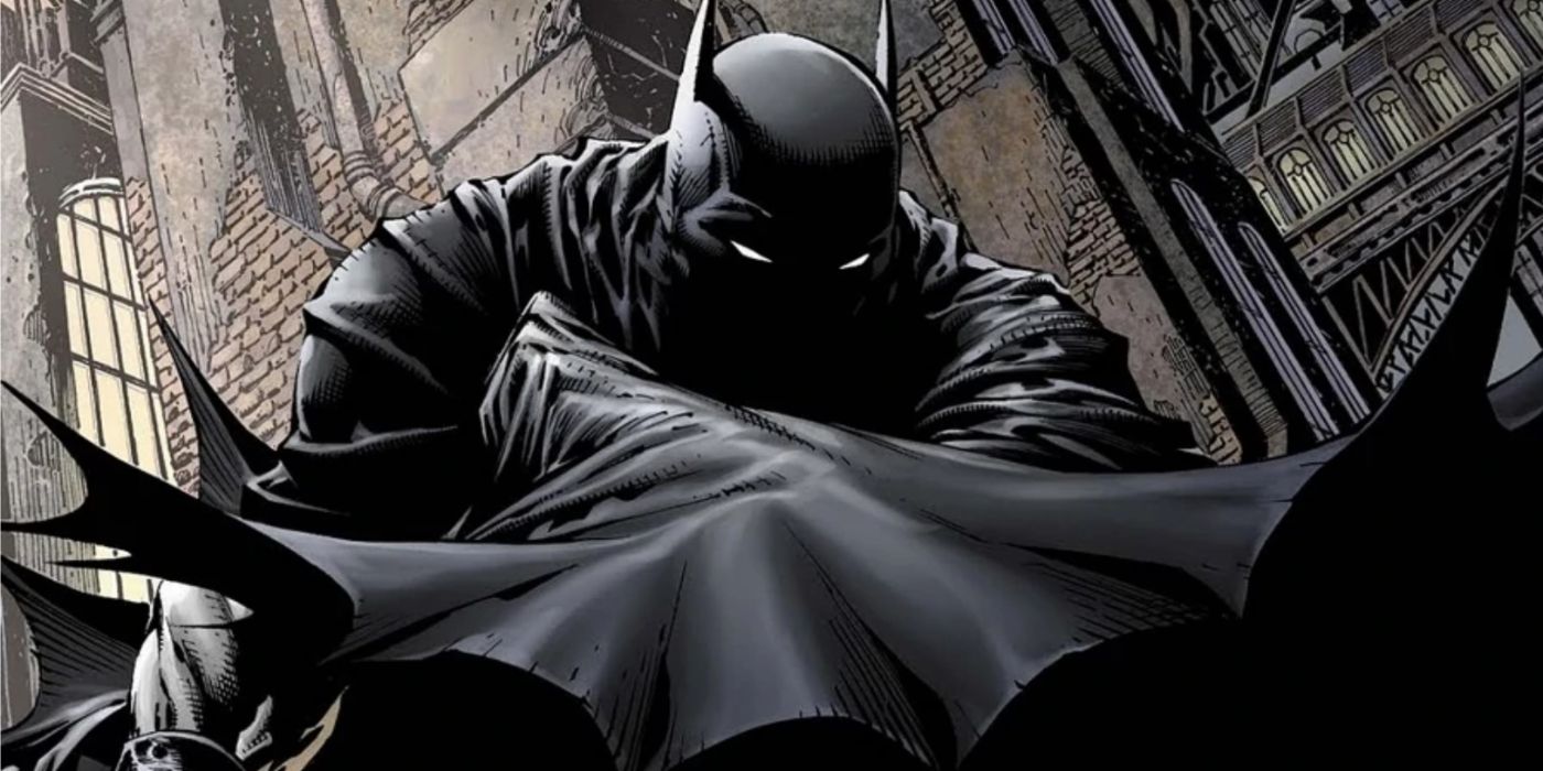 Batman empoleirado no topo de um prédio envolto por sua capa e sombras na DC Comics.