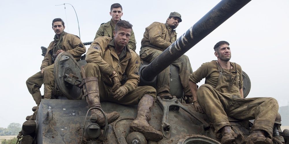 A number of men sit on a tank in Fury