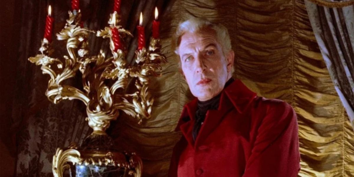 Vincent Price in a red suit in front of a gold curtain in The Fall Of The House Of Usher