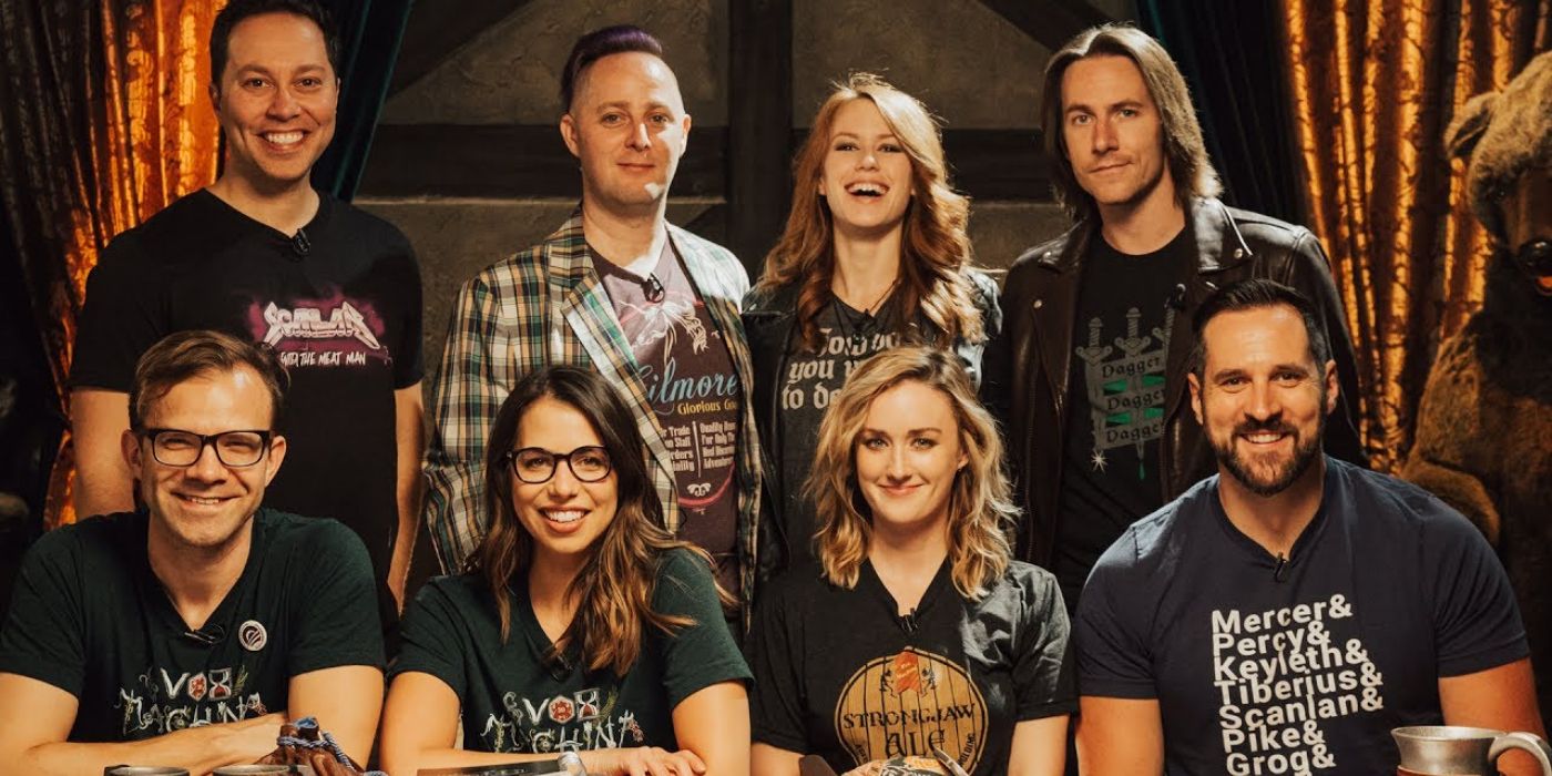 The Critical Role cast posing at the table in two rows of four