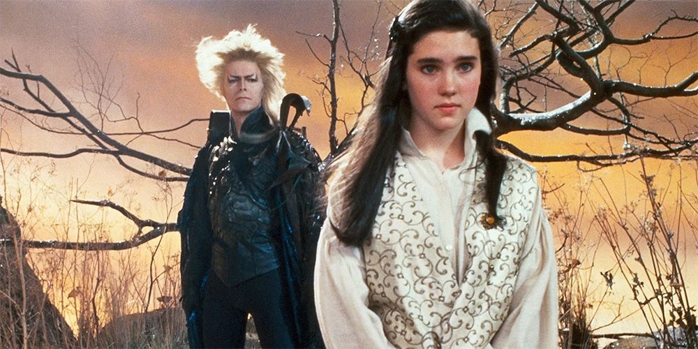 A girl stands and looks on as the goblin king looks on in Labyrinth