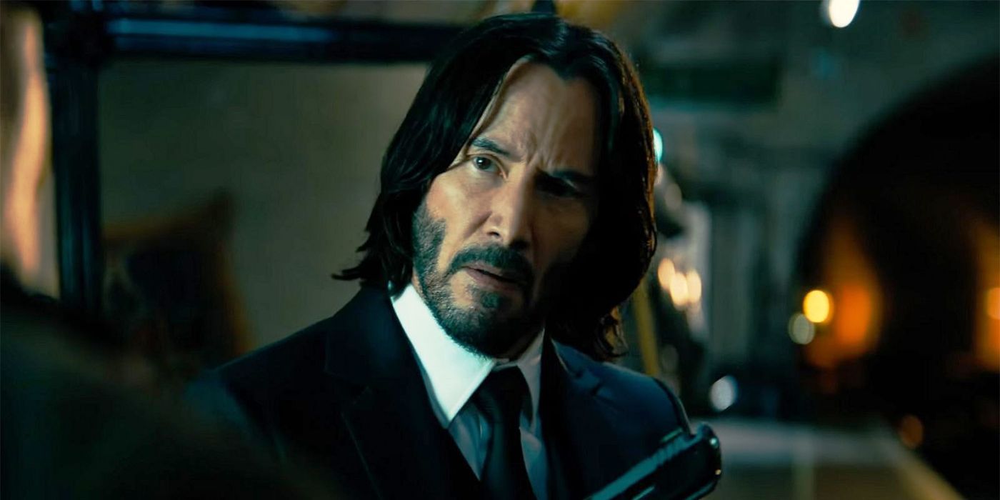 John Wick holding a gun and looking concerned in Chapter 4