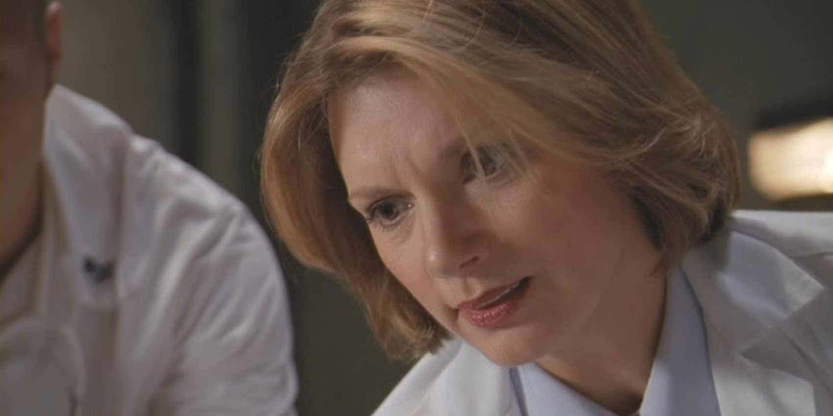 Stargate SG-1 Janet Fraiser looks worriedly down at a patient