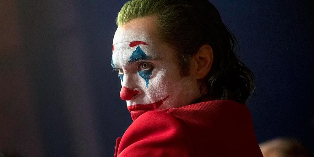 Joaquin Phoenix's Joker sitting down with an angry face.
