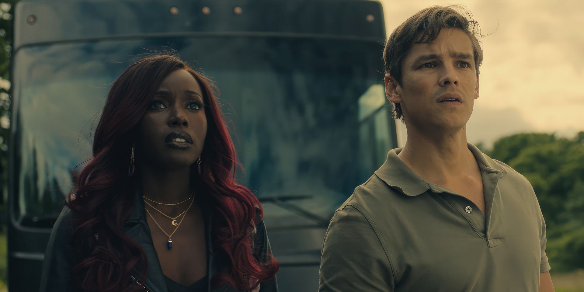 Starfire et Nightwing des Titans, joués par Anna Diop et Brenton Thwaites, regardent nerveusement quelque chose devant un bus
