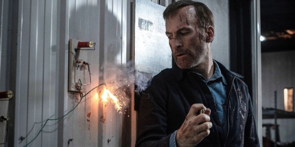 Bob Odenkirk looking at a sparking wire in the movie Nobody