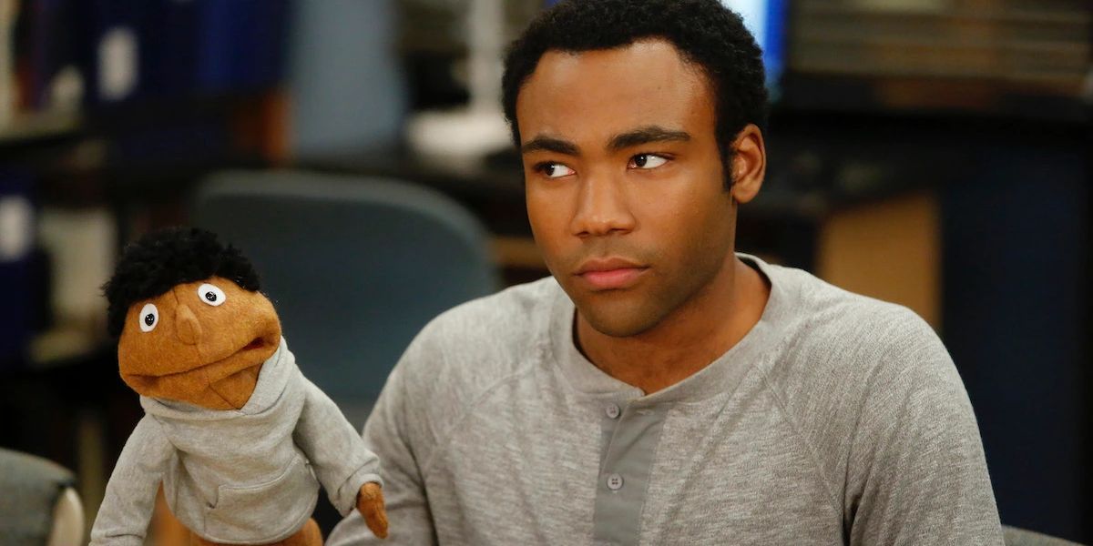 Troy Barnes (Donald Glover) holding a puppet of himself in Community Season 4