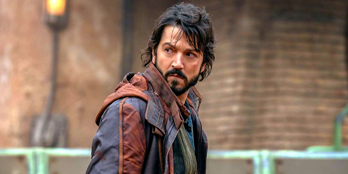 Wearing a brown and blue jacket, Cassian Andor looks over his shoulder in Andor