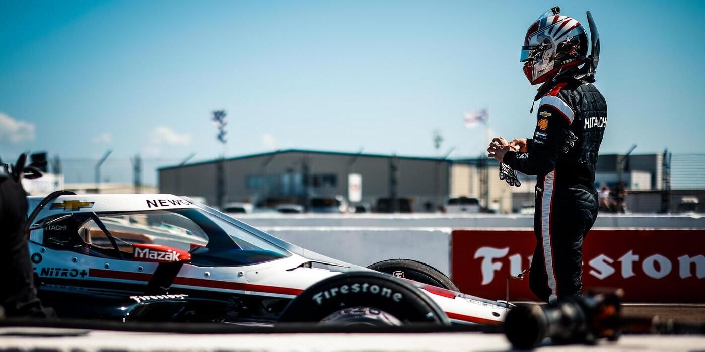 O piloto da IndyCar, Josef Newgarden, fica ao lado de seu carro no pit lane