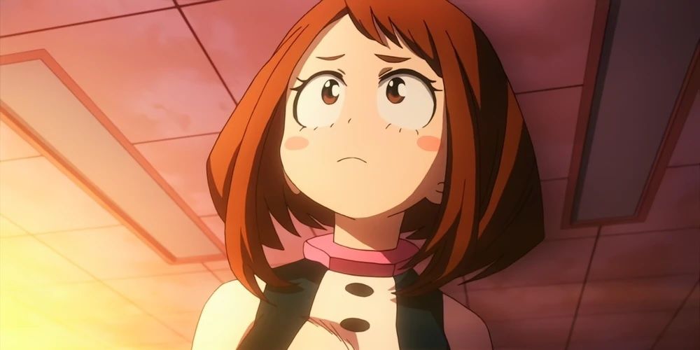 Ochaco Uraraka na escola em sua fantasia de herói parecendo preocupada em My Hero Academia.