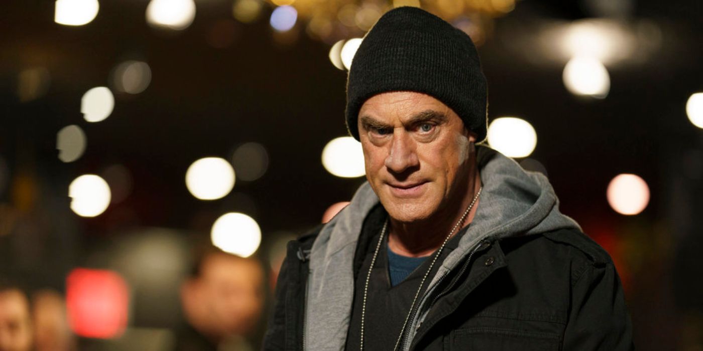 org crime s3 e18 stabler (Christopher Meloni) parecendo mal-humorado em um gorro cercado por luzes fora de foco à noite