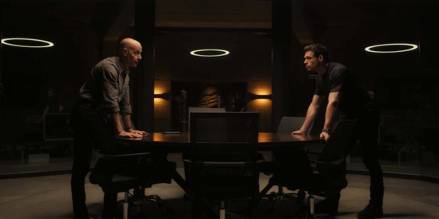 Mason (Madden) and Bernard (Tucci) talking on opposite sides of a table in Citadel