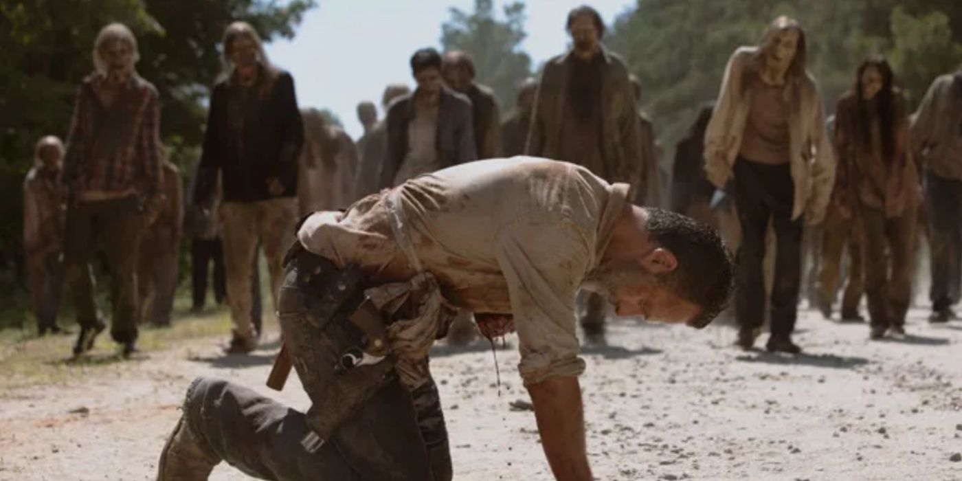 Rick se inclina enquanto sangra enquanto os caminhantes se aproximam em The Walking Dead. 