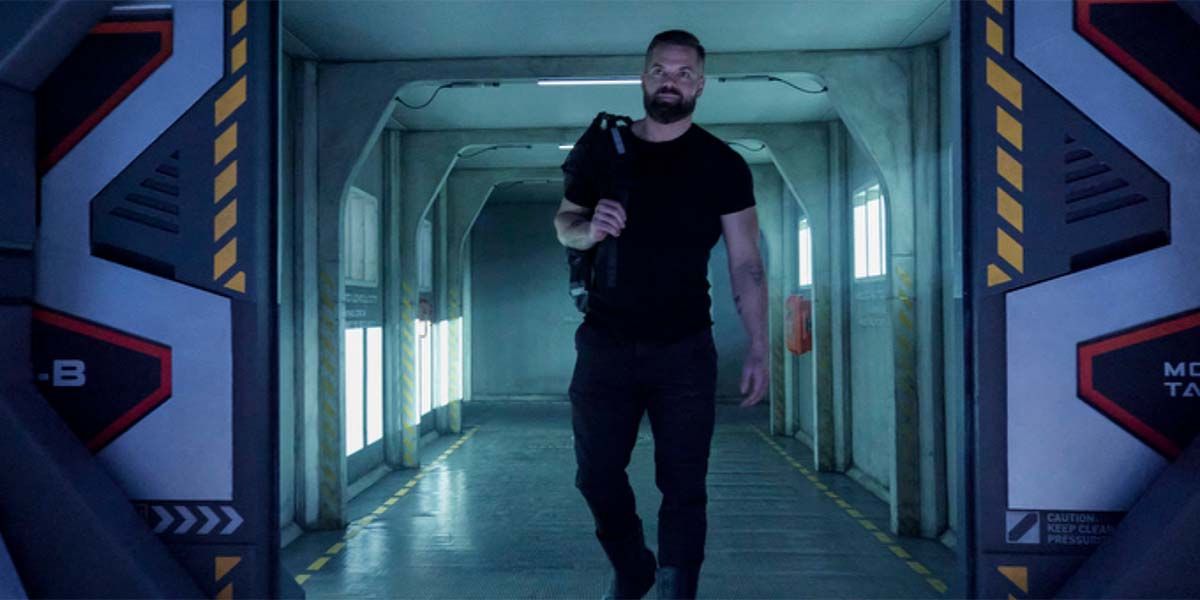 Wes Chatham como Amos Burton caminhando pelas portas de um navio em The Expanse