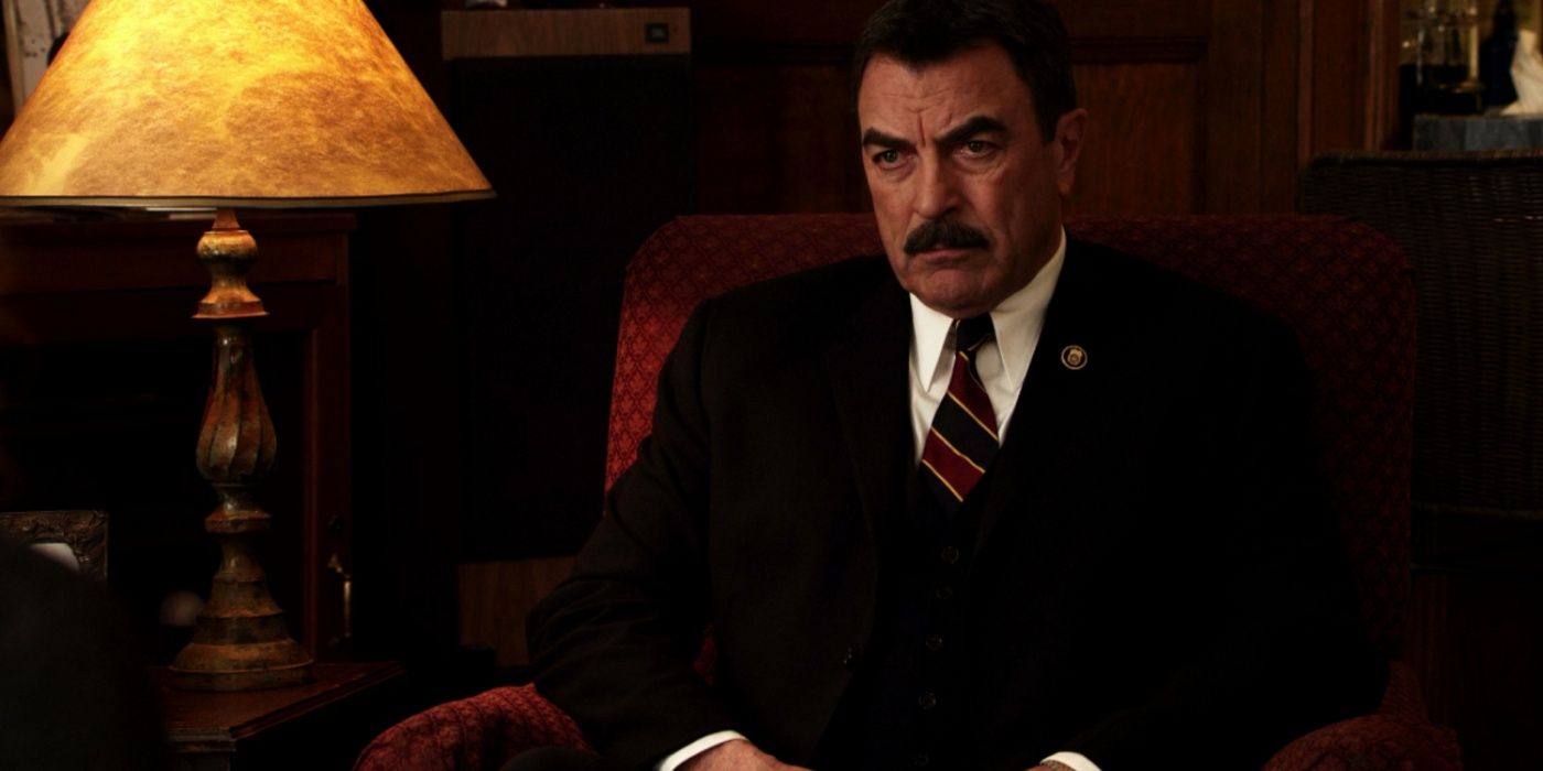 Blue Bloods' Frank Reagan sitting in a chair looking serious next to a lamp