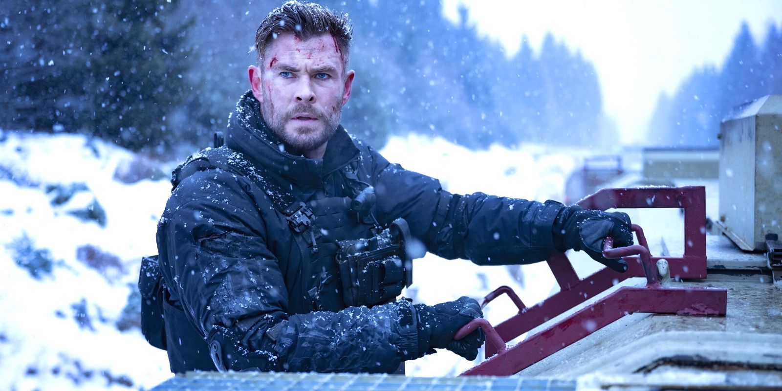 Chris Hemsworth looking stoic as he clutches to the side of a snow-covered train