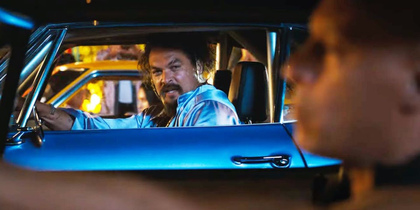 Jason Momoa looks at Vin Deasel through his car window in Fast X