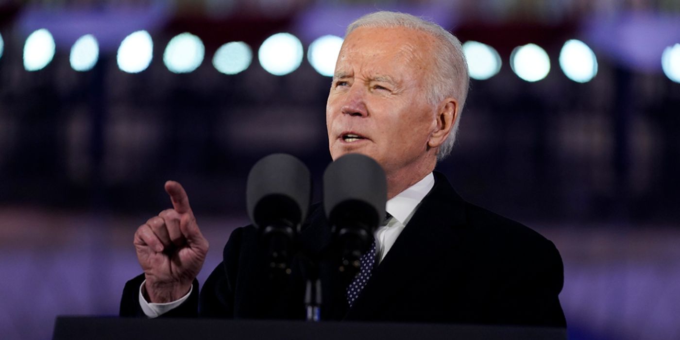 United States President Joe Biden standing behind a podium in a dark suit during an evening event