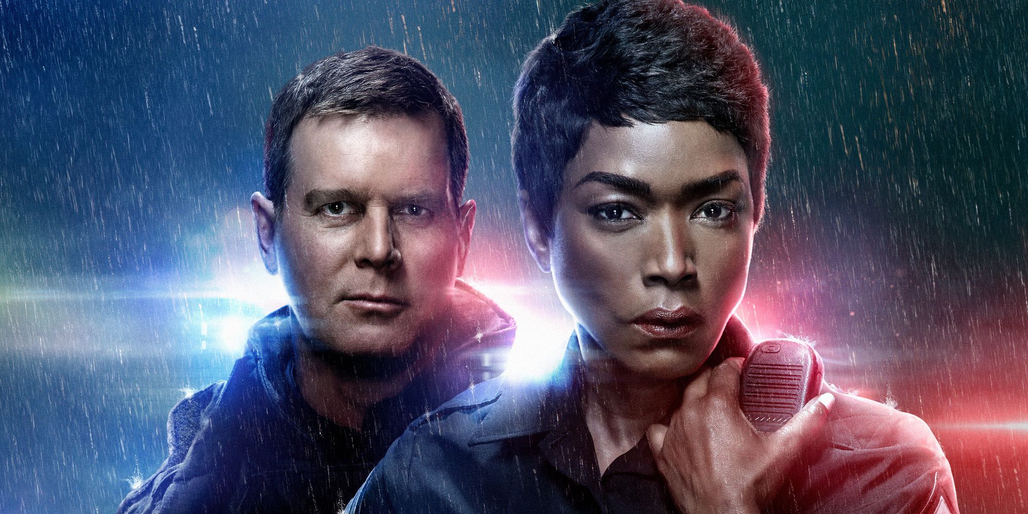 Angela Bassett and Peter Krause in the rain in front of blue and red lights on 9-1-1