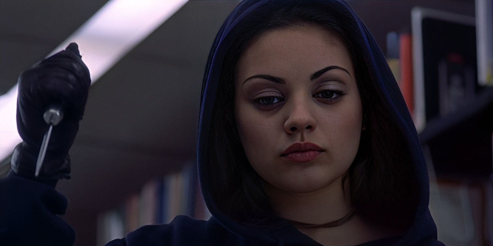 Rachael de Mila Kunis segurando uma faca na biblioteca em American Psycho 2.