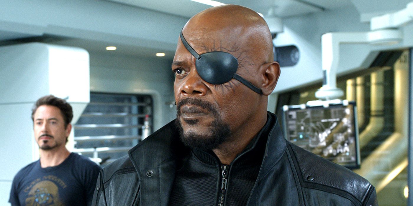 Nick Fury stares at something while Tony Stark stands in the background in The Avengers