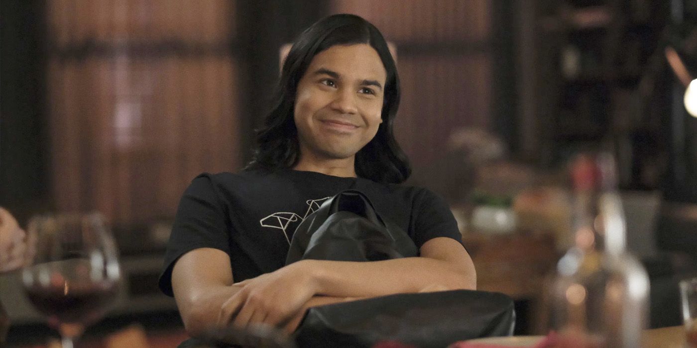 Cisco Ramon sitting with his arms crossed over a backpack and smiling in The Flash