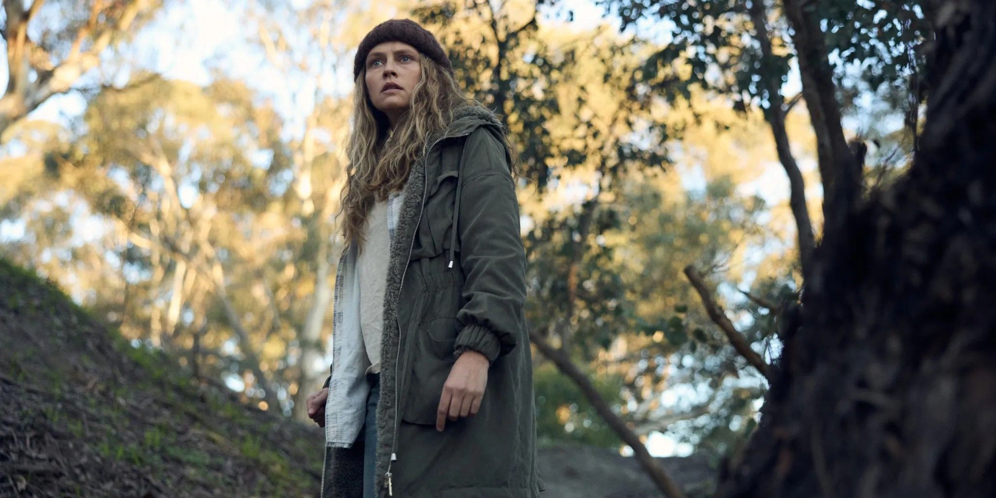 Teresa Palmer as Freya standing in the woods in Hulu's the clearing
