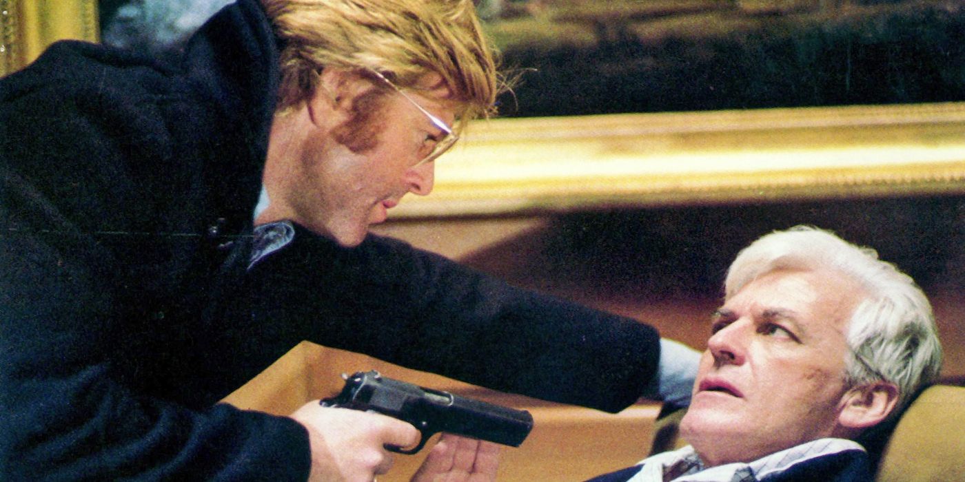 Joe Turner (Robert Redford) aponta uma arma para um homem em Três Dias do Condor.