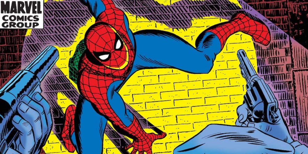 Spider-Man up against a wall at gunpoint