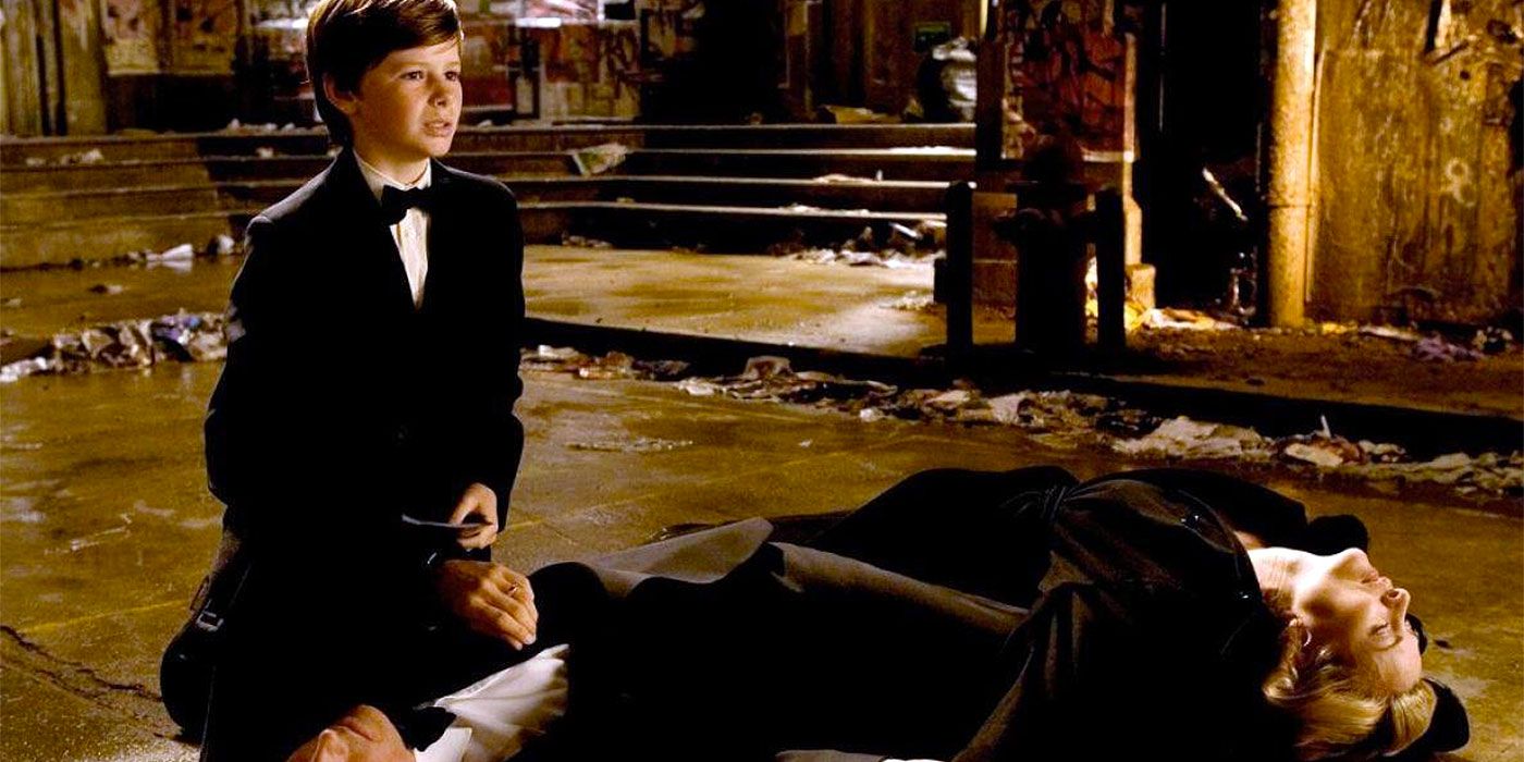 Gus Lewis as young Bruce Wayne standing over his parents' bodies in Batman Begins