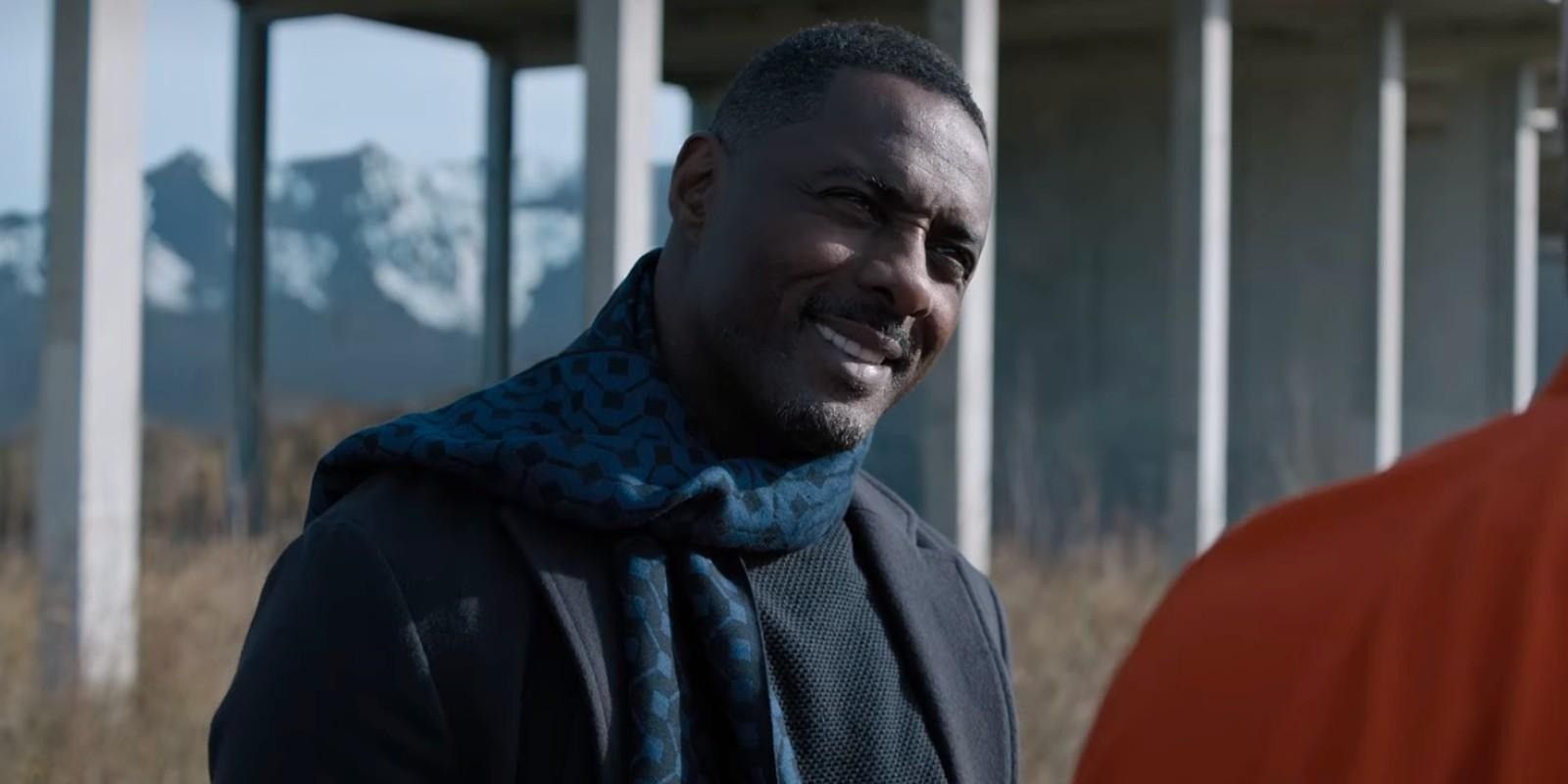 Alcott de Idris Elba sorrindo em um viaduto em Resgate 2