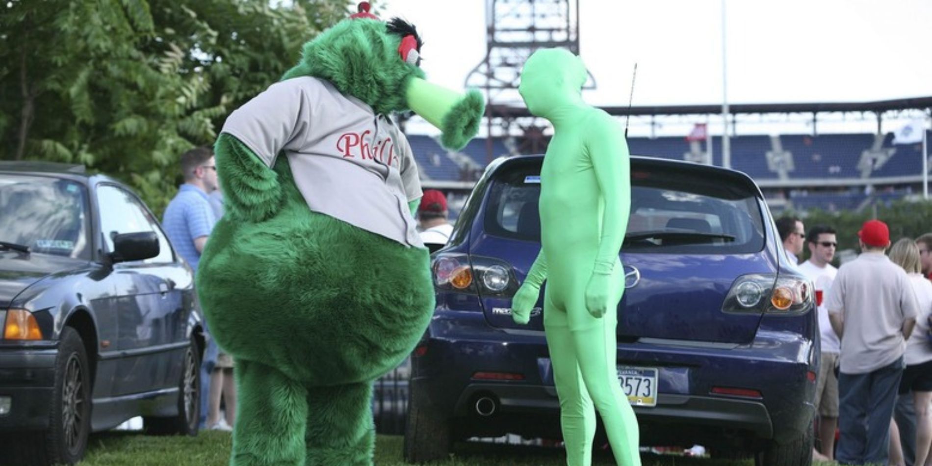 Está sempre ensolarado na Filadélfia Charlie Kelly como Green Man enfrentando o mascote do Philadelphia Phillies, Phillie Phanatic, em um estacionamento fora do Citizen's Bank Park em 