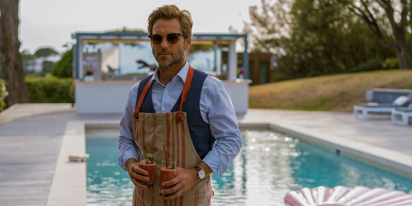 Jamie Bamber's Harry stands by the pool in a scene from Cannes Confidential