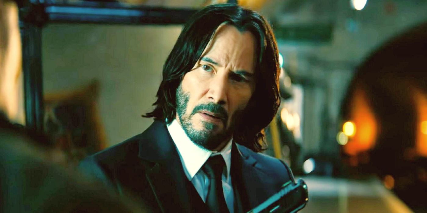 Keanu Reeves in a suit holding a gun in John Wick Chapter 4