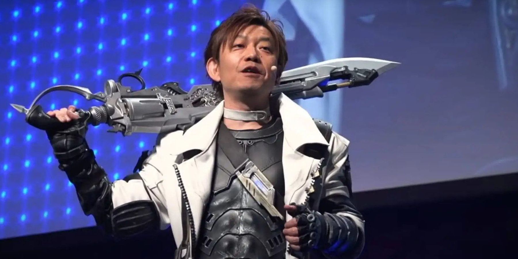 Naoki Yoshida with a Gunblade over his shoulder at a Final Fantasy XIV event