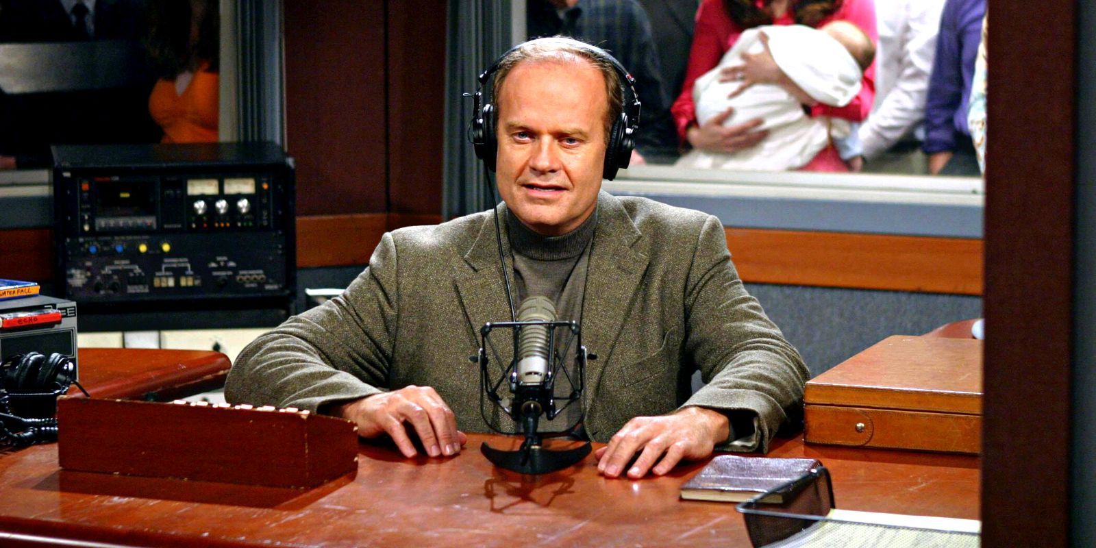 Frasier sitting at his desk with a microphone in front of him