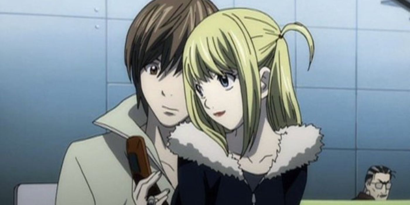 Light Yagami and Misa Amane snuggling on a couch in Death Note. 