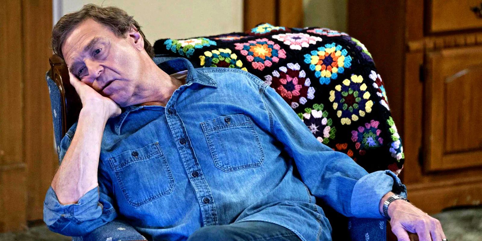 John Goodman slouched on the couch in The Conners