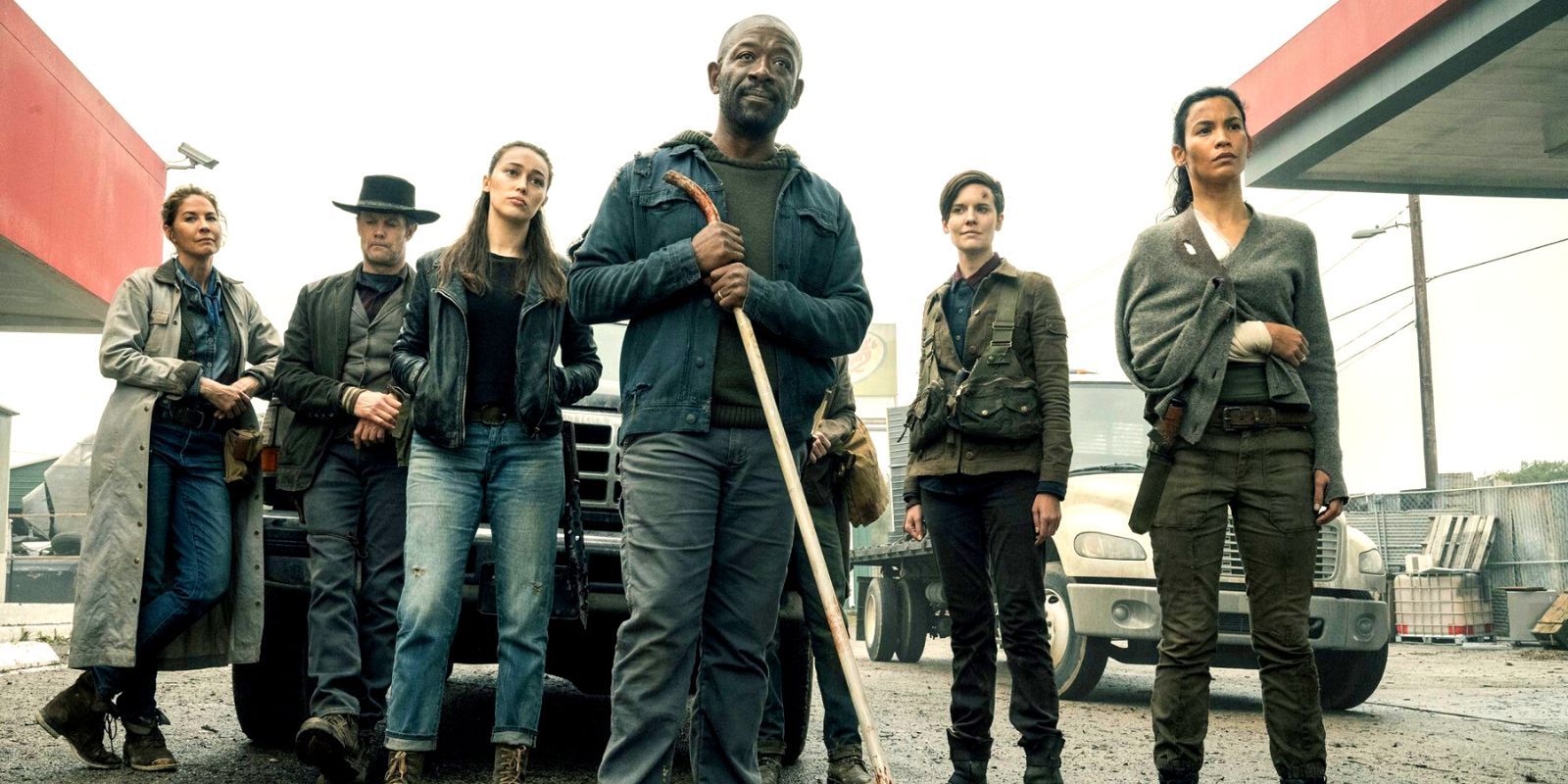 The full cast of Fear the Walking Dead posing in a derelict gas station.