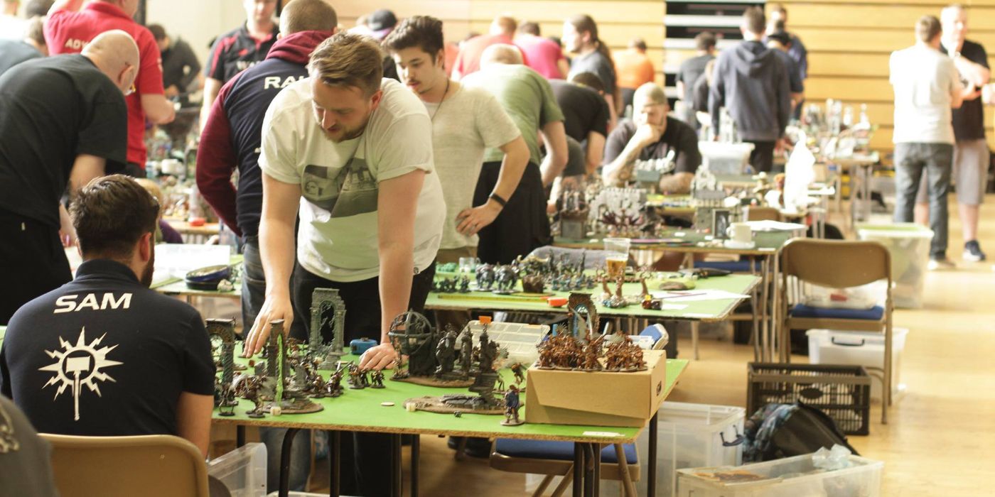 Uma sala cheia de jogadores Warhammer 40k durante um torneio