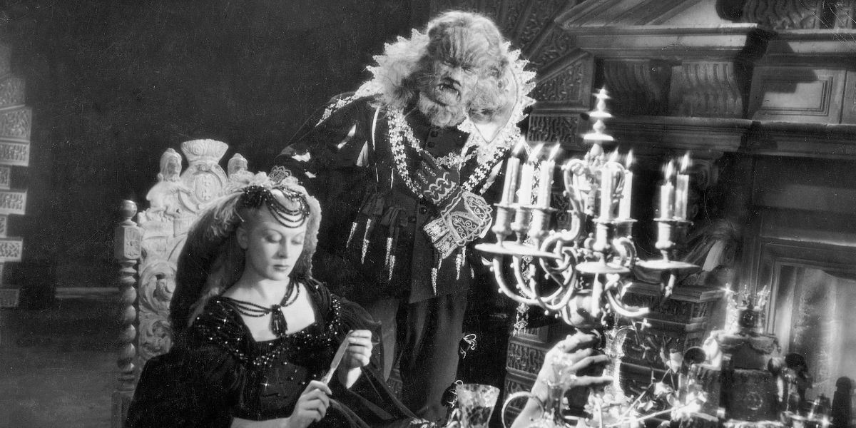 Belle sitting at the dinner table with the Beast standing behind her in La Belle et la Bete